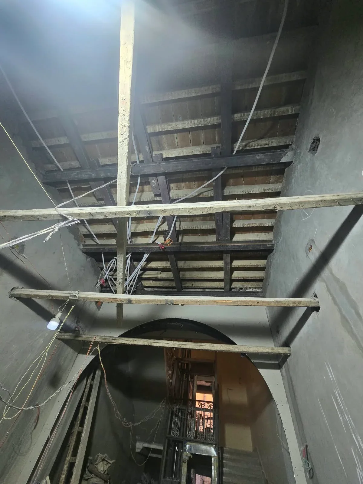Lobby during ceiling preparation, with internal scaffolding and a lift and staircase behind