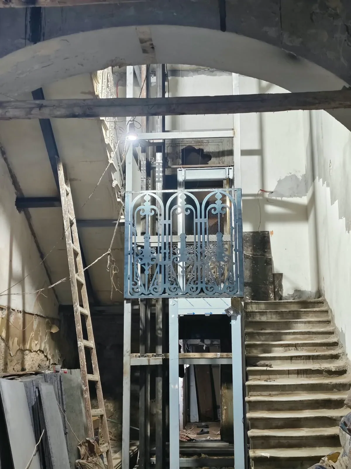 Arch, lift and staircase during finishing, with unfinished surfaces