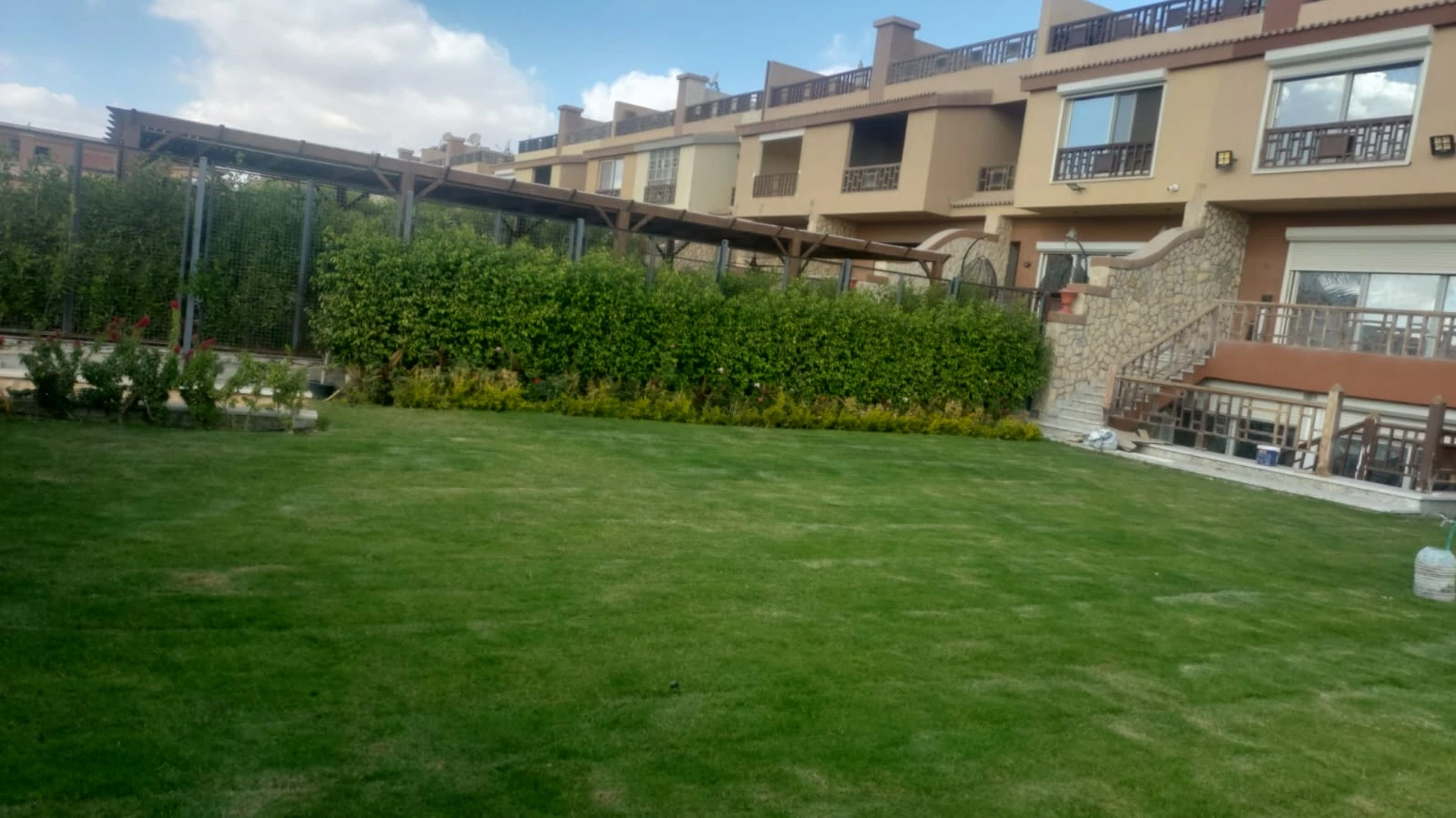 Green lawn and planting beds in front of residential buildings